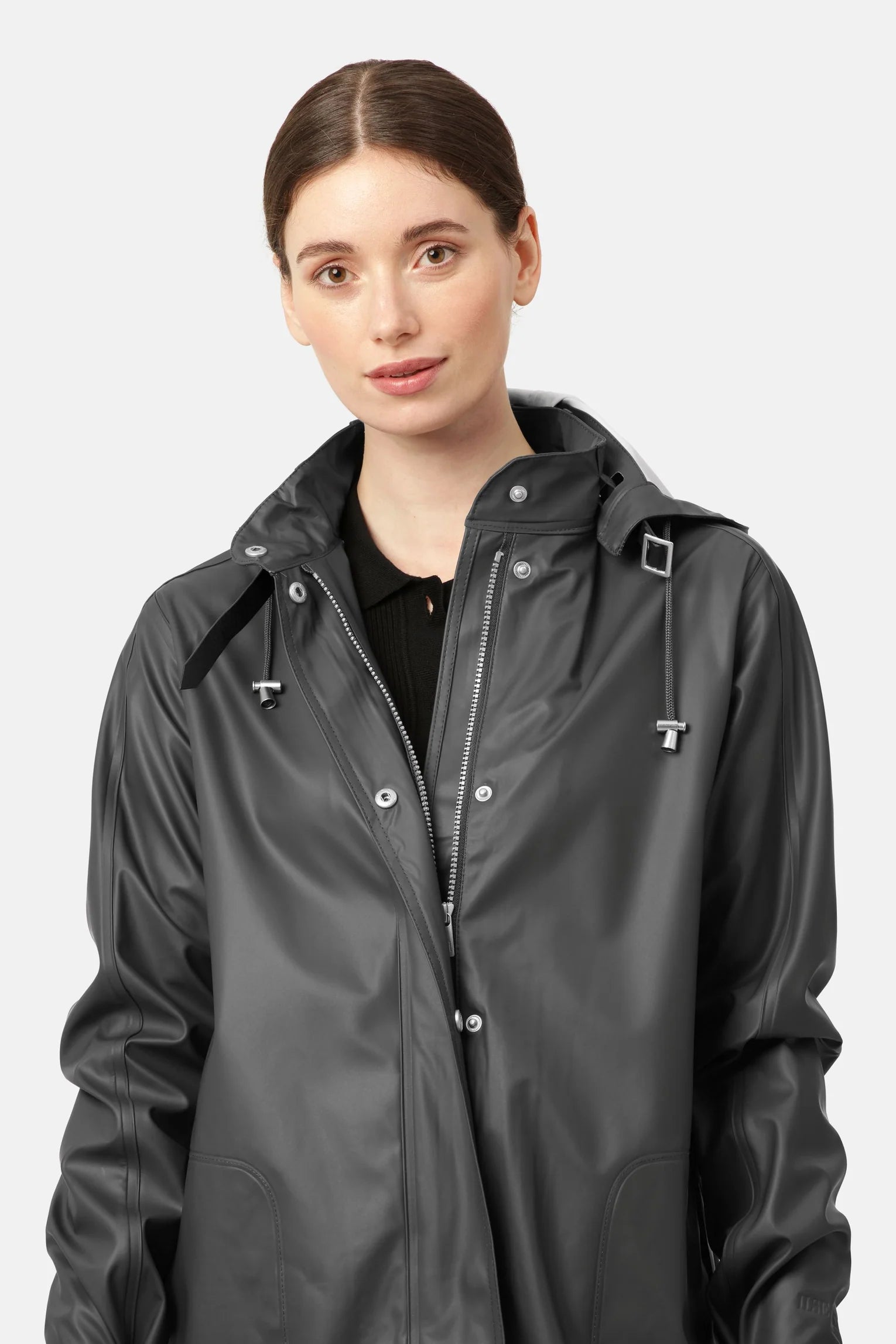 Knee length black rain coat with hood and hidden press buttons.