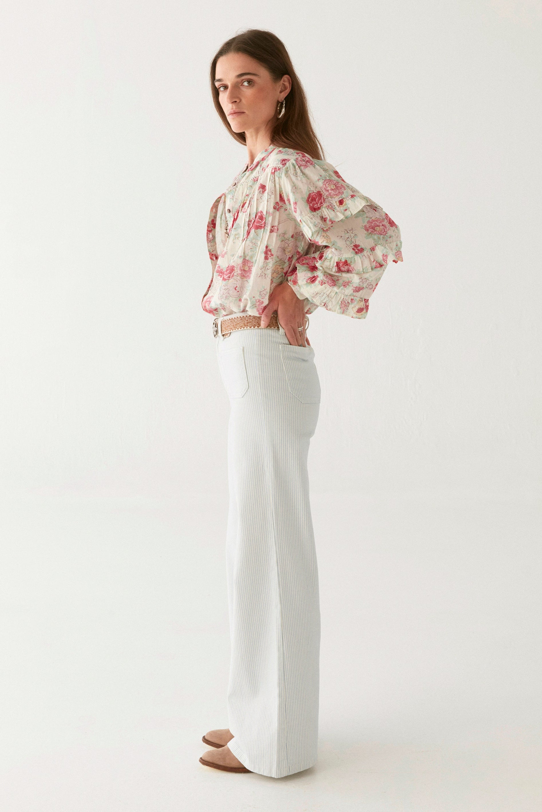 Pink floral blouse with ruffle sleeves on modal on a white background.