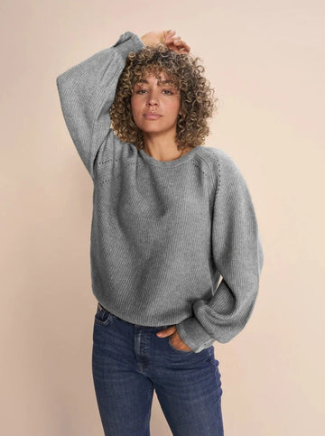 Grey knitted long sleeve sweater with loos silhouette and o-neck with feminine cuff detail. 