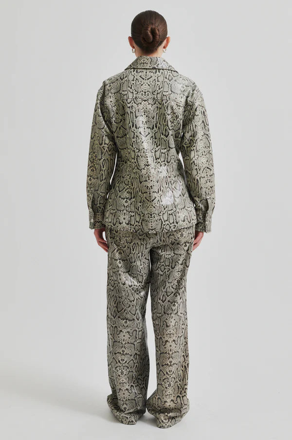 Model wearing mid rise wide leg leather pants with snake skin pattern and matching jacket.