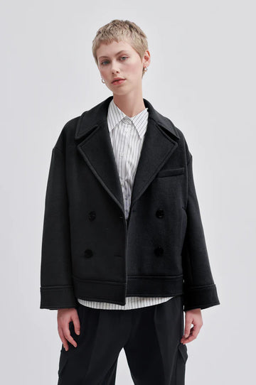 Black double breasted jacket. Wide lapel, sleeves with straps and button cuffs.  Wide boxy fit. 