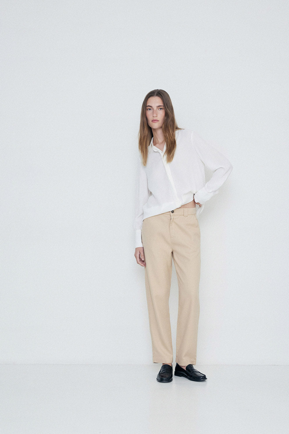 Beige straight leg trouser with elastic back and button and fly front closure. Back and side pockets.