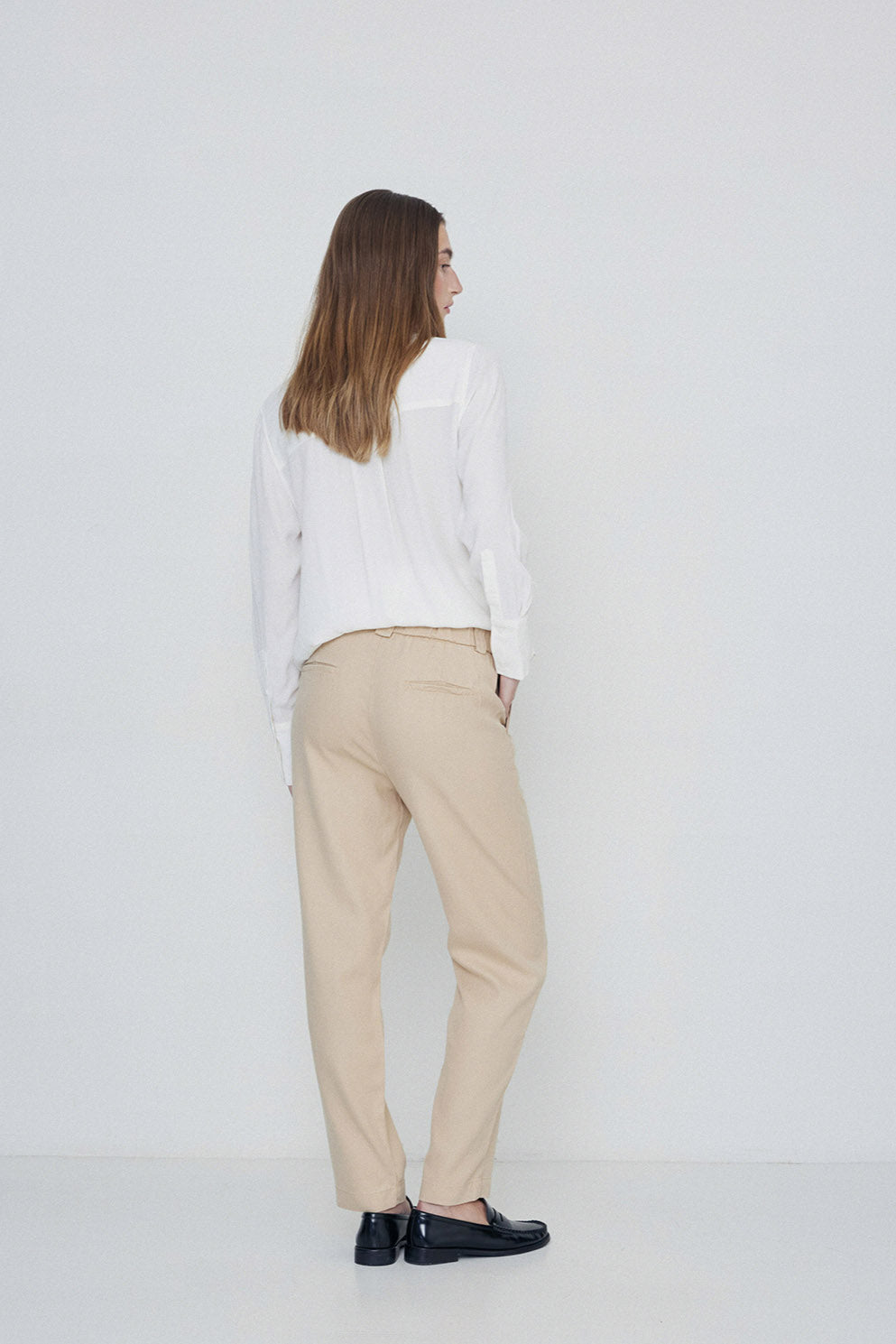 Beige straight leg trouser with elastic back and button and fly front closure. Back and side pockets.