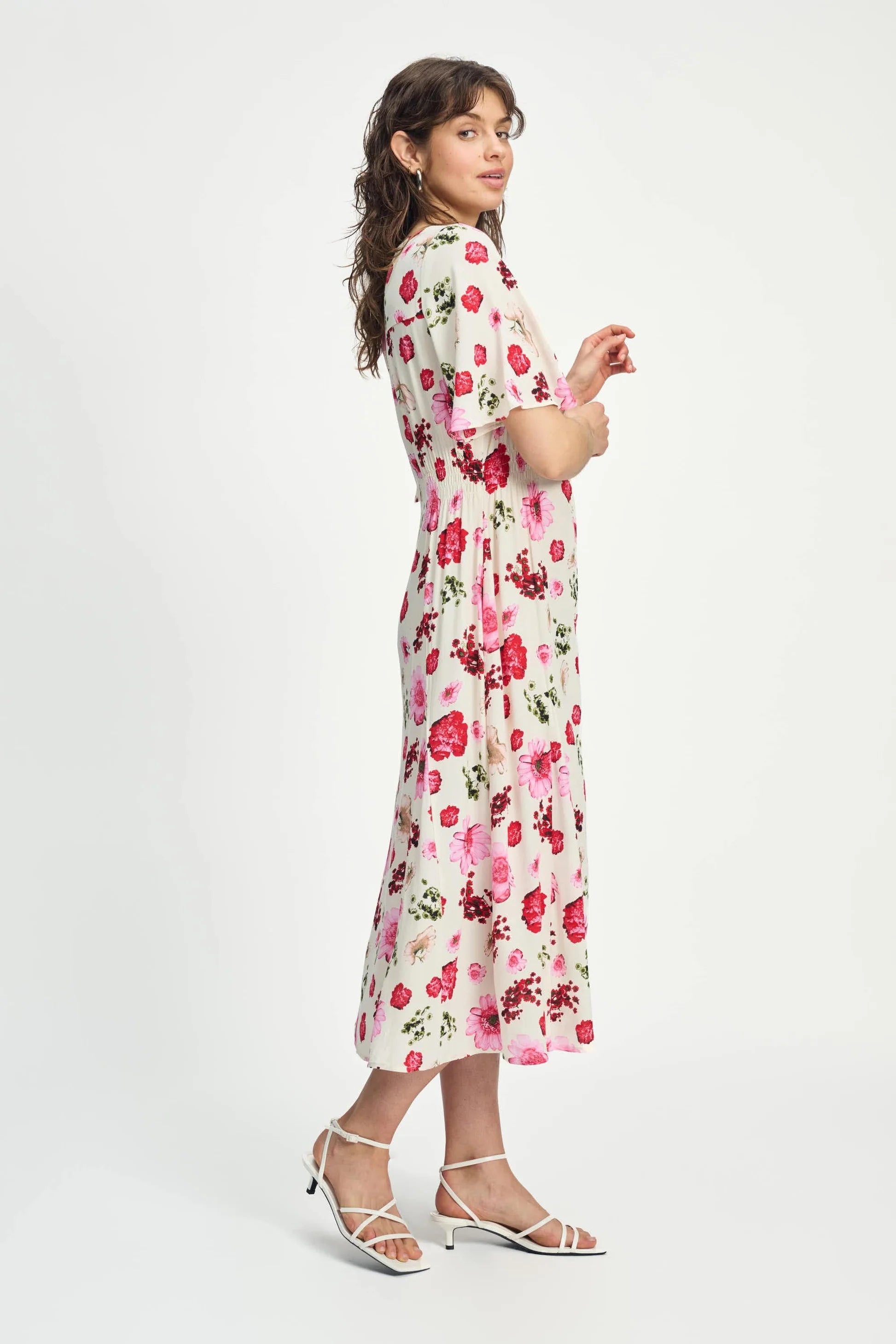 Woman wearing a floral short sleeve midi dress on a white background