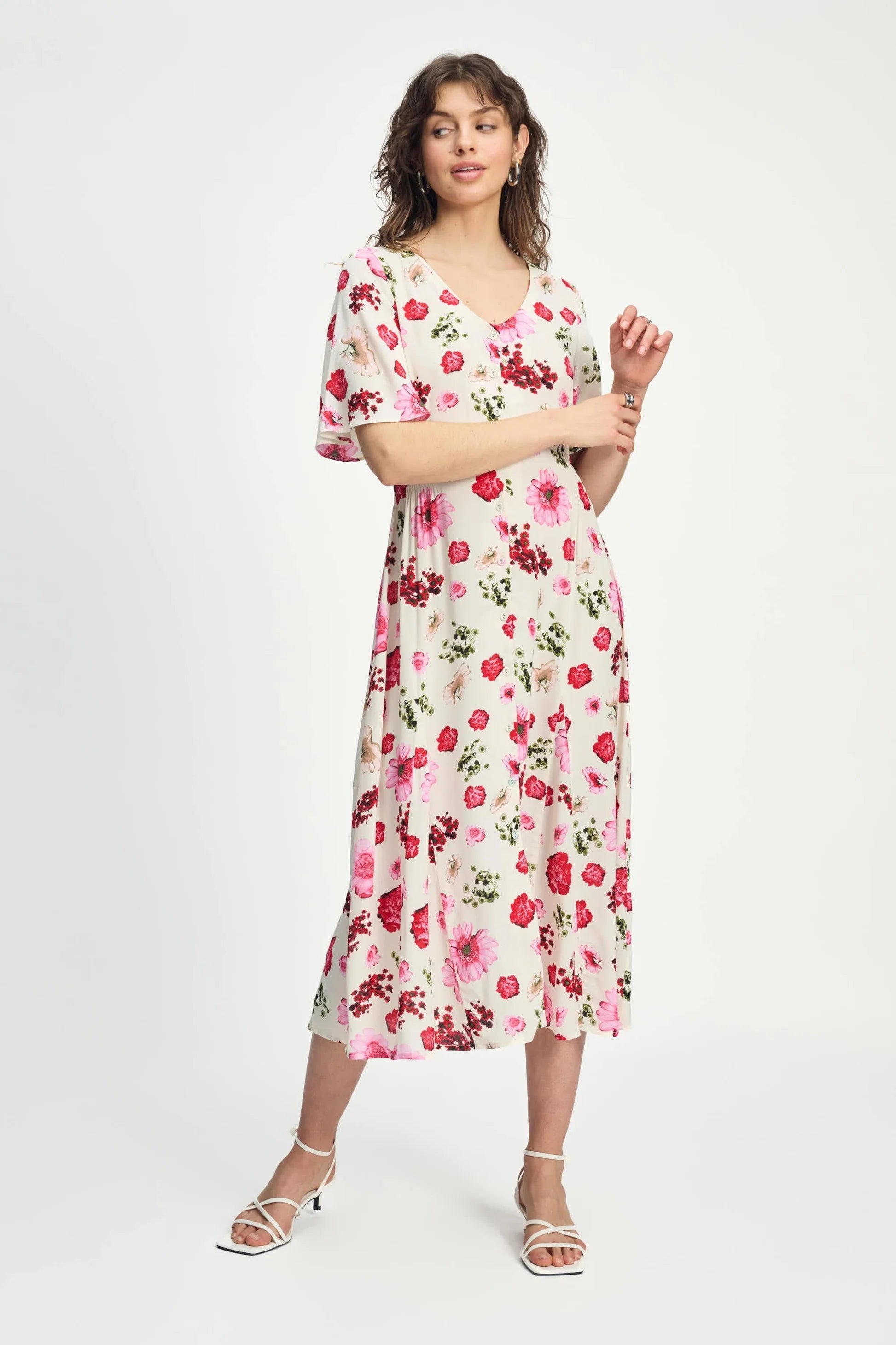Woman wearing a floral short sleeve midi dress on a white background