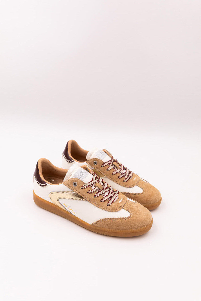 Pair of tan and white sneakers on a light gray background