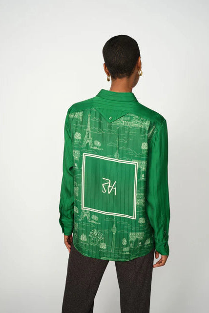 Person wearing a green patterned shirt with a logo on a white background