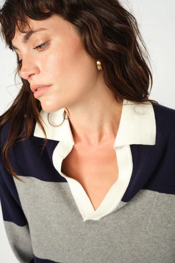 Woman wearing a striped shirt with a white collar on a plain background