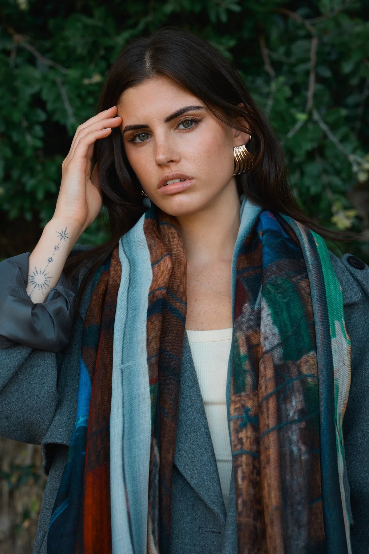 Woman wearing a patterned scarf with a blurred natural background