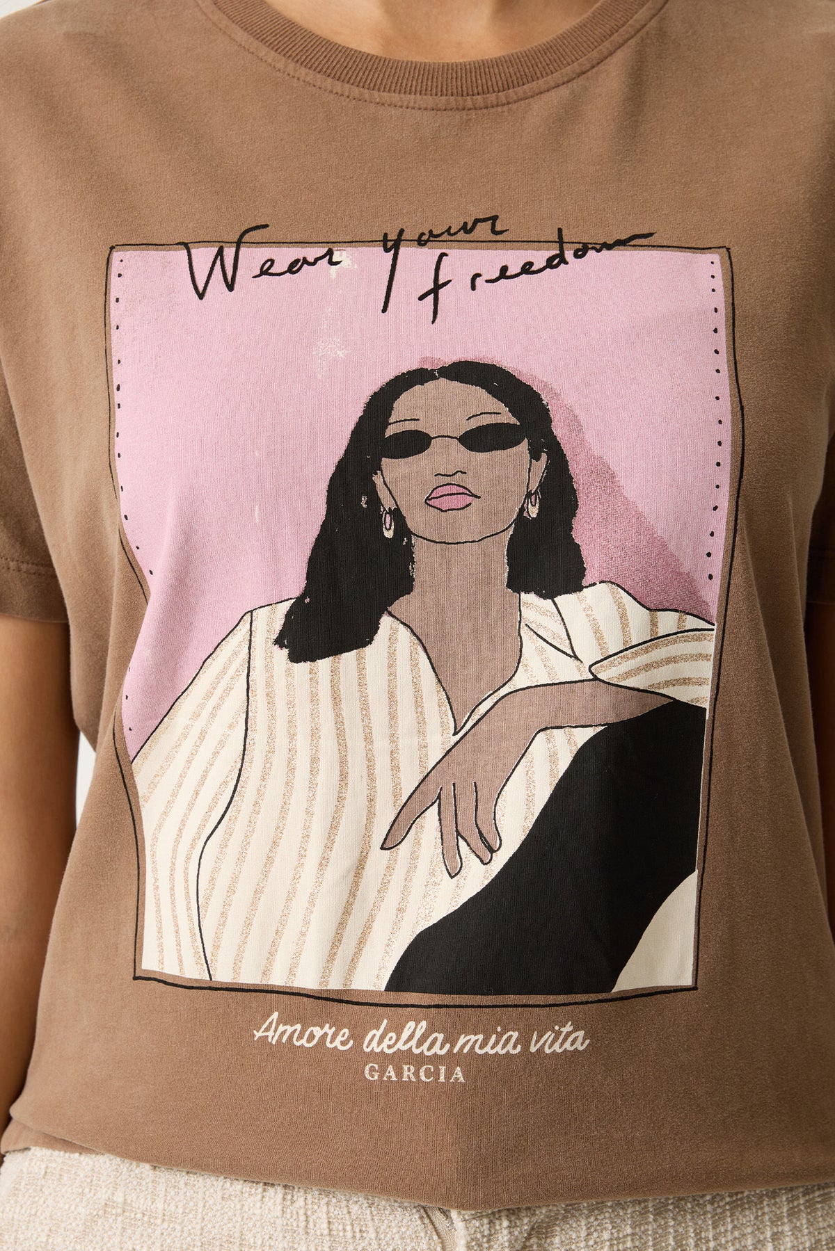 Brown t-shirt with an illustration of a woman and text on a pink background