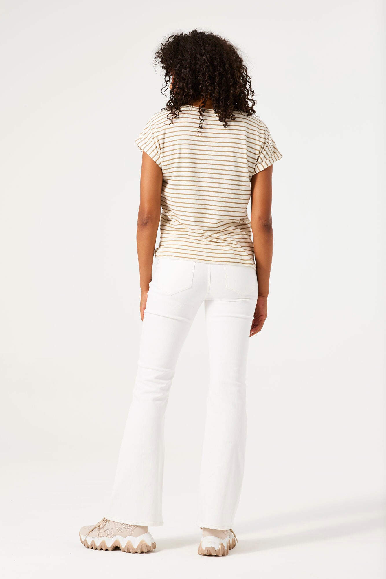 Person wearing a striped shirt and white pants on a white background