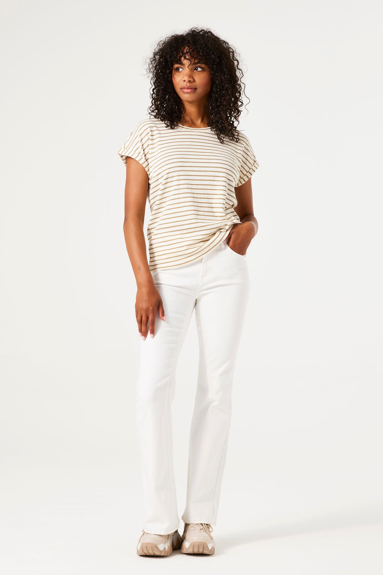 Woman wearing a striped shirt and white pants on a white background