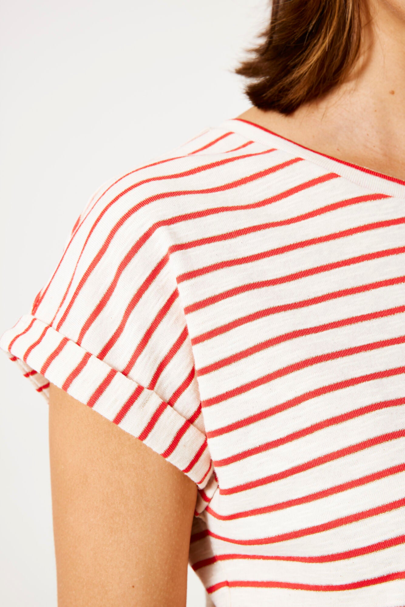 Close-up of a person wearing a red and white striped shirt on a plain background