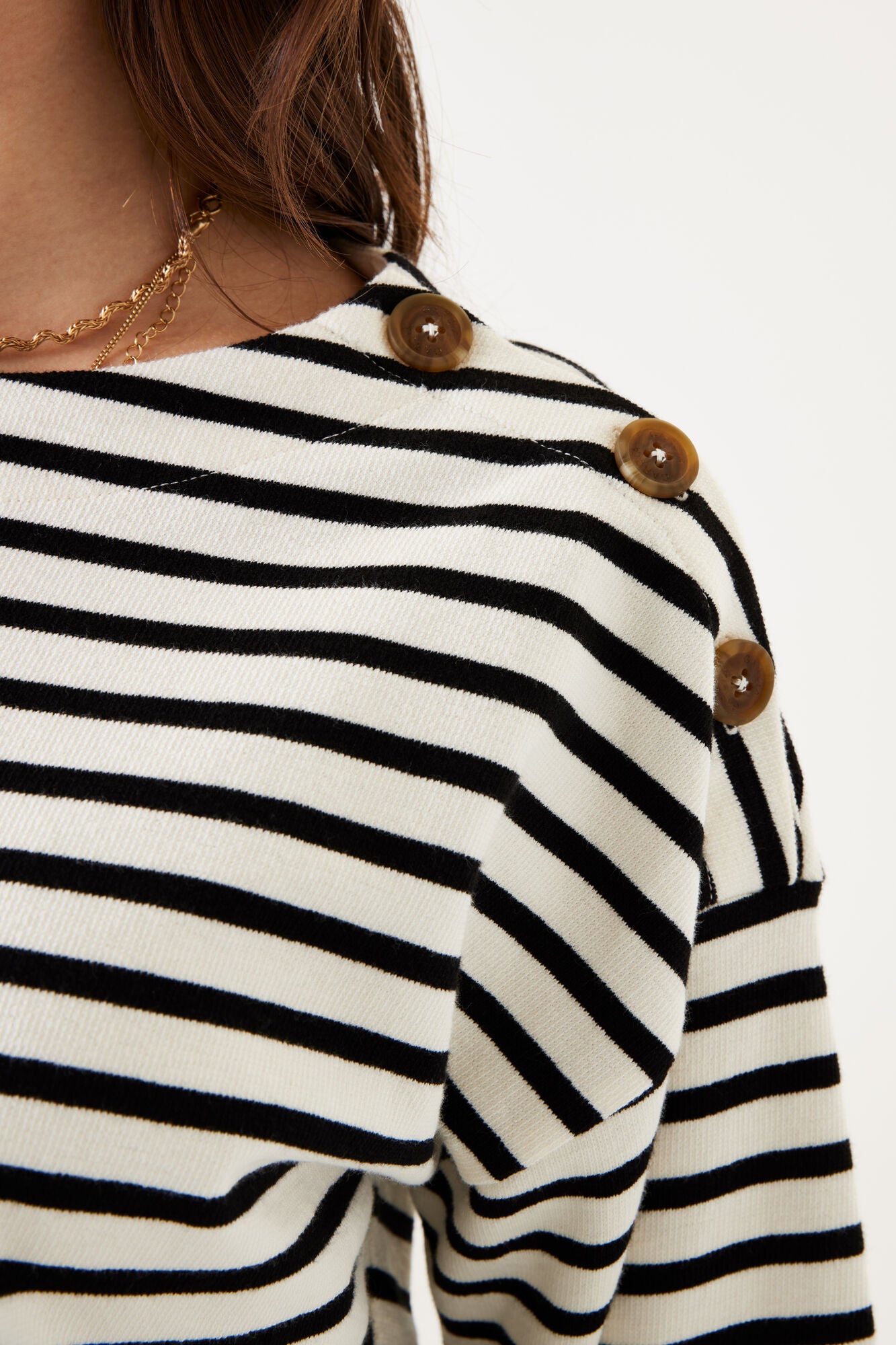 Black and white striped shirt with wooden buttons on a plain background