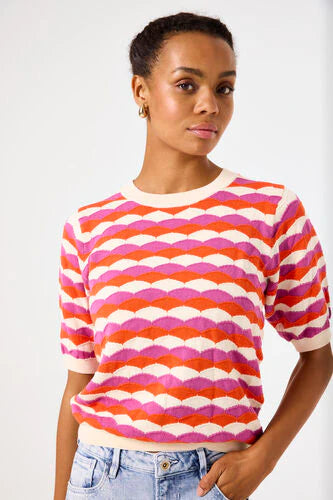 Woman wearing a colorful striped sweater against a white background