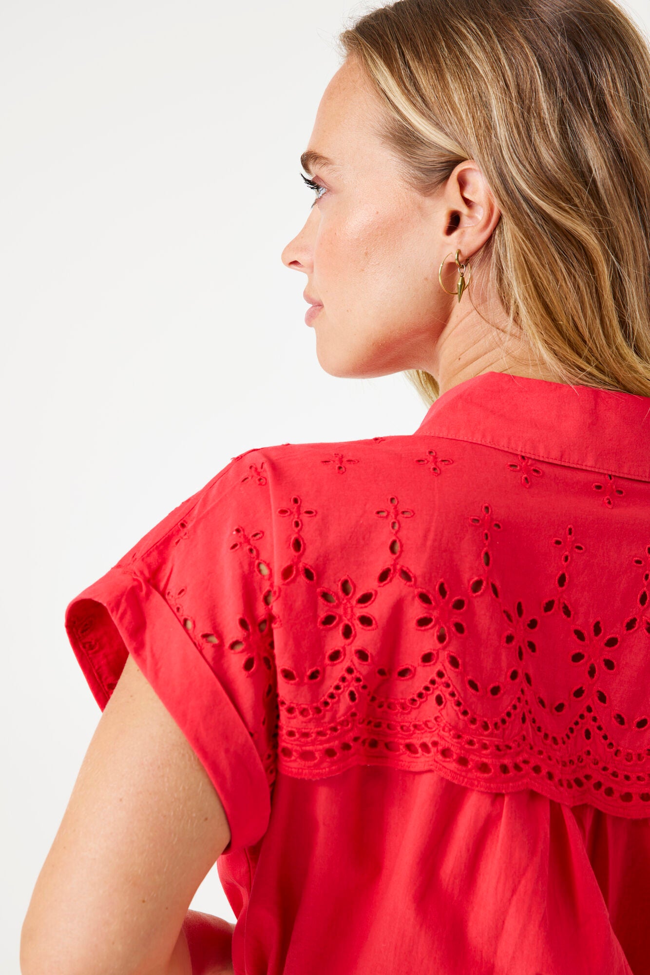 Model wearing short sleeve ruby red midi dress with broderie top. 