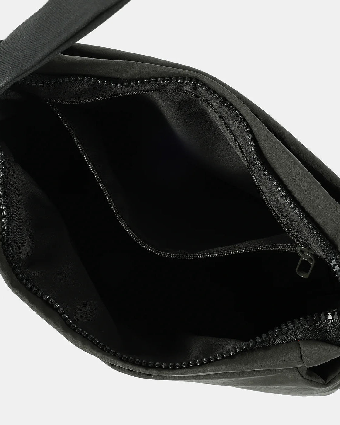Inside of Olive green cross body bag with lining a visible zipper on a white background