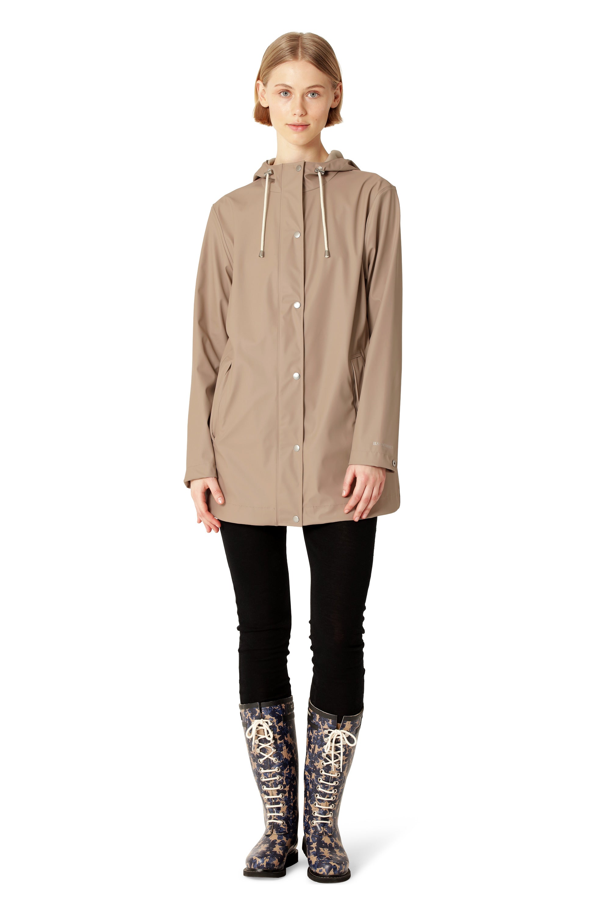 Woman wearing a beige raincoat and patterned boots on a white background