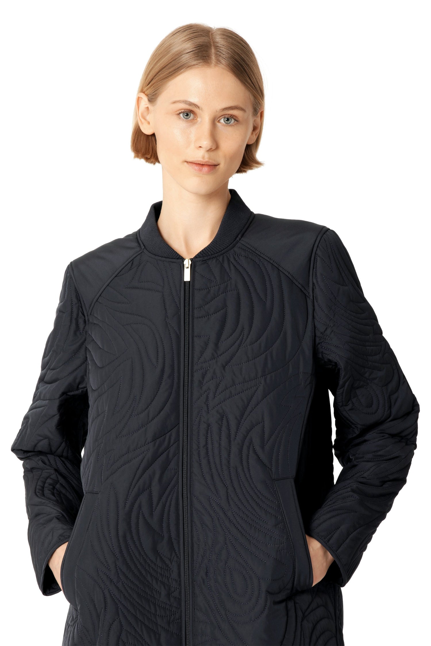 Woman wearing a dark navy quilted jacket on a white background