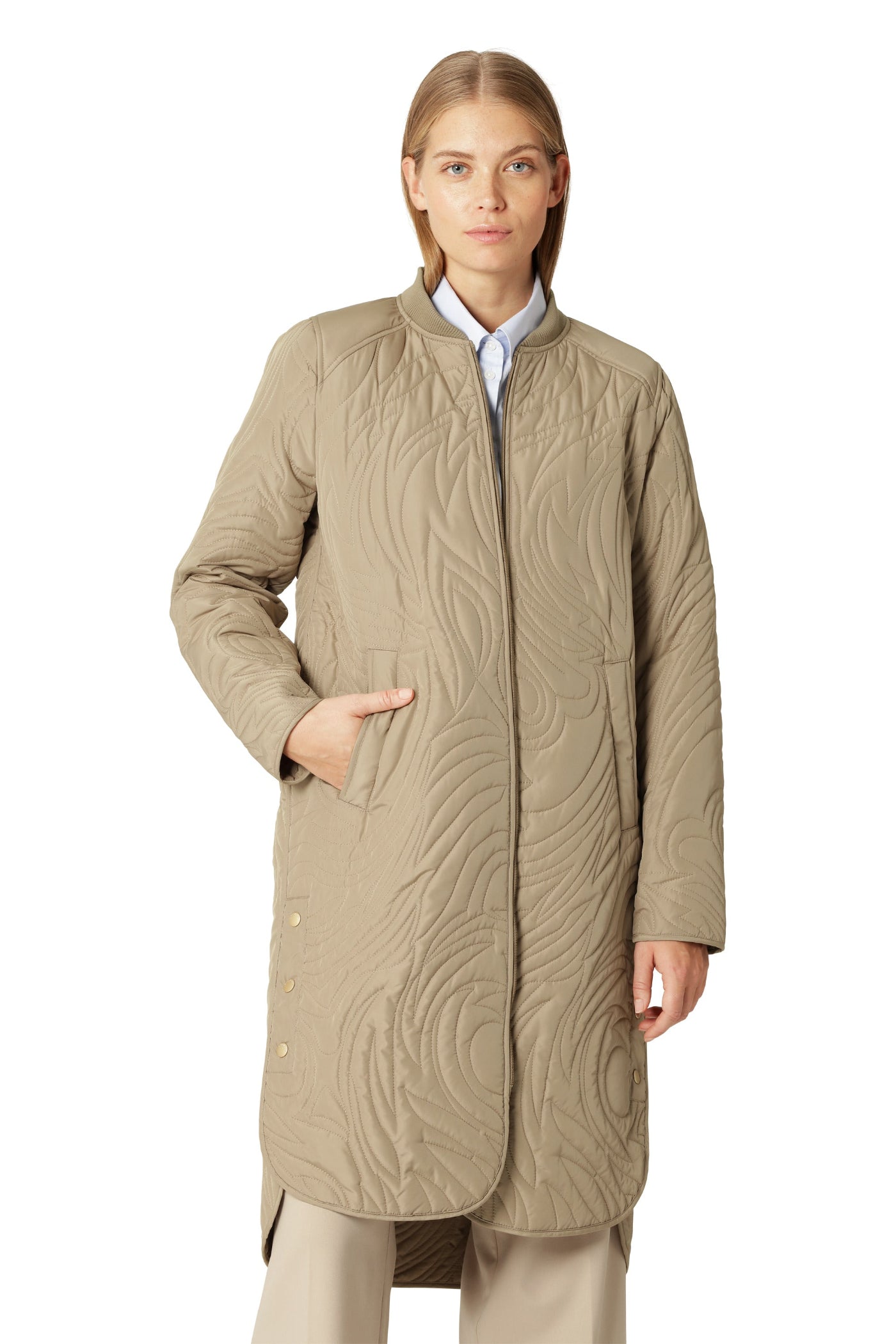 Woman wearing a beige quilted coat on a white background