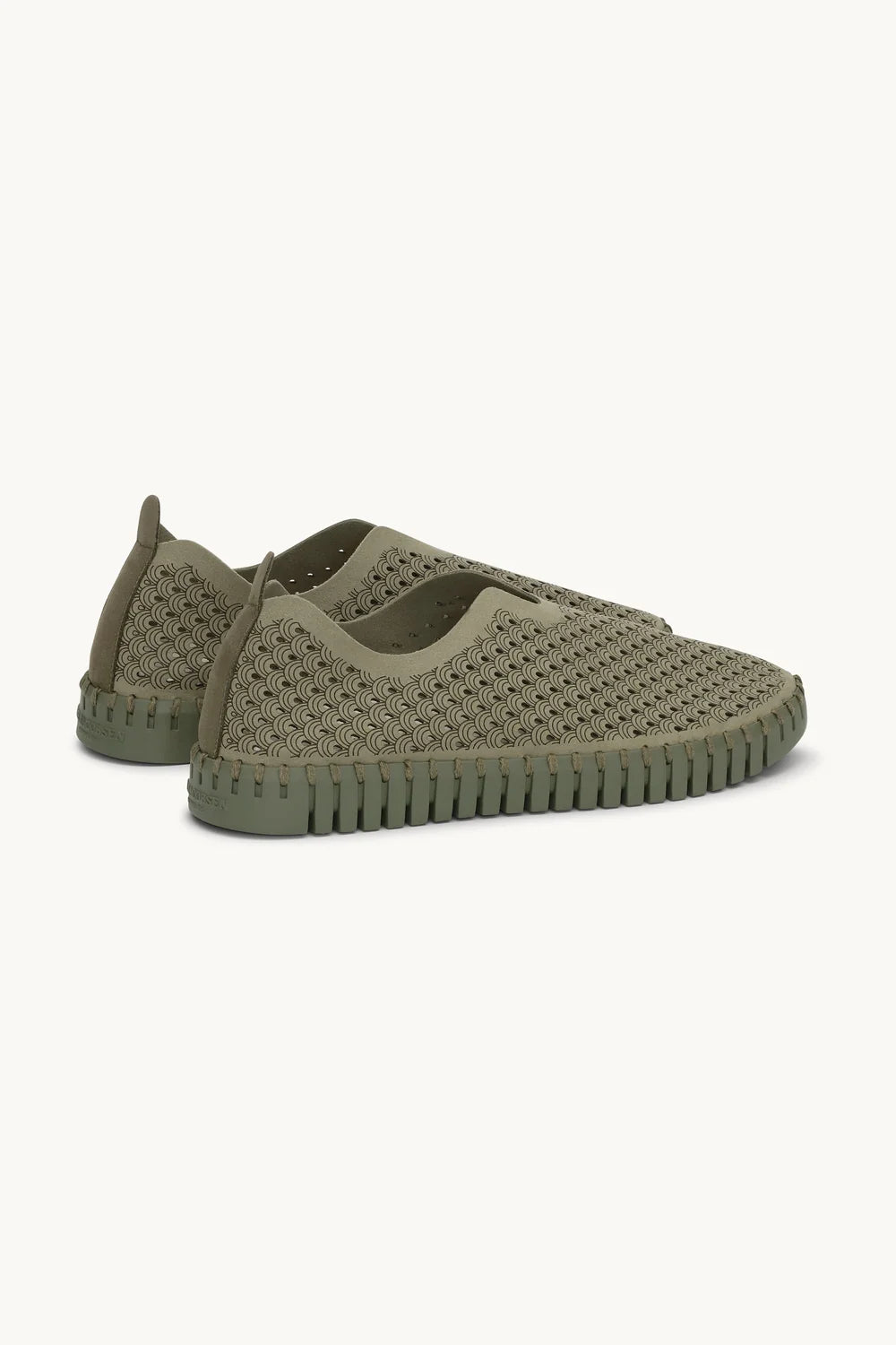 A pair of slip on Tulip shoes by Isle Jacobsen in olive green with slightly darker sole on a plain background. 