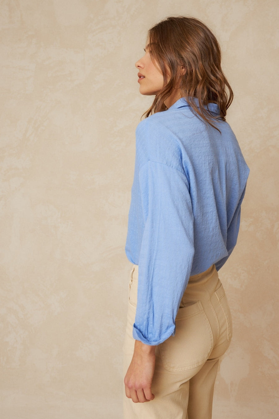 Blue Cotton Shirt with classic collar and dropped shoulder. White buttons and wide sleeves side on. 