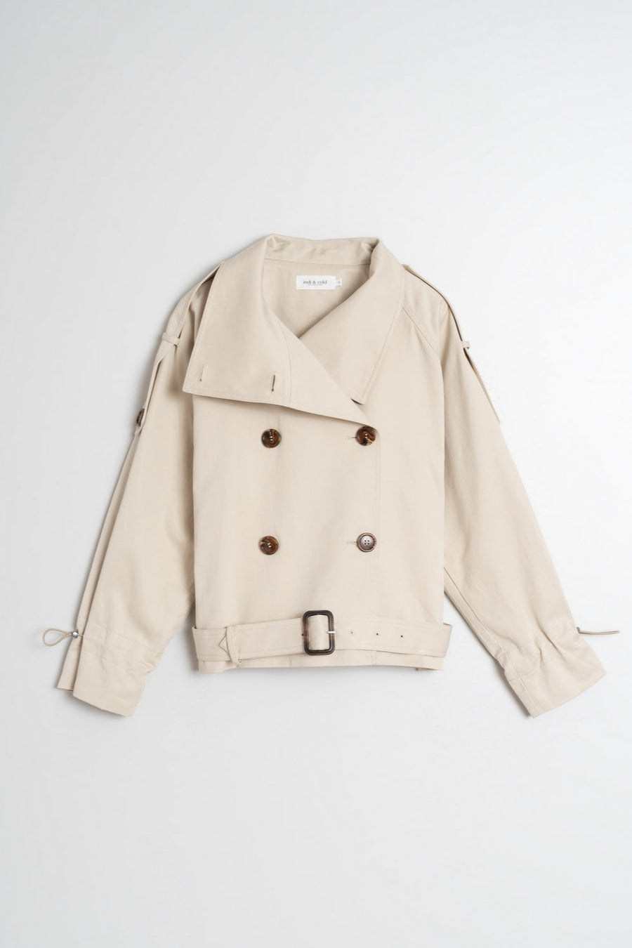 Beige double breasted cropped trench coat with belt.