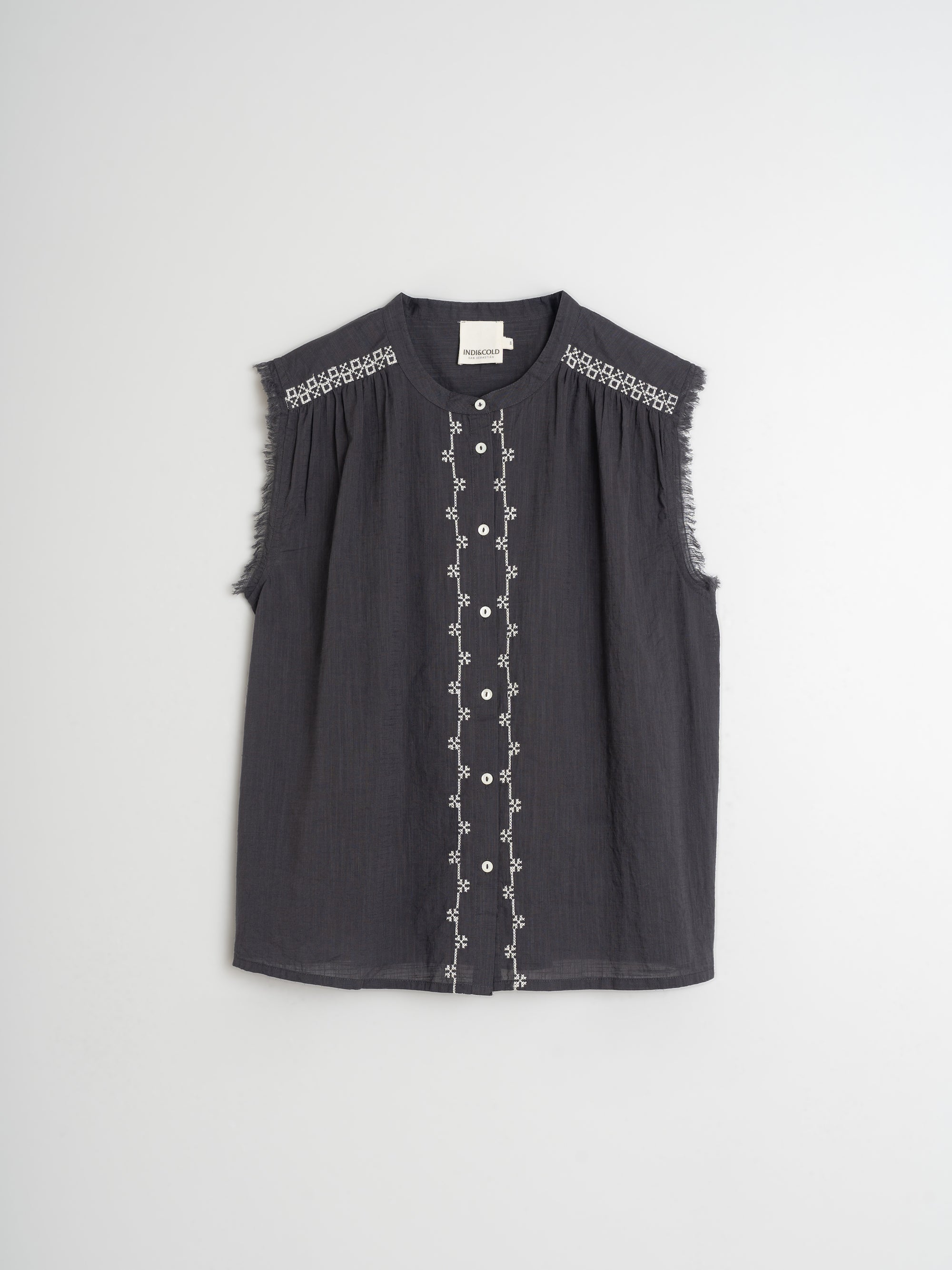 Black sleeveless top with white embroidery on a light grey background