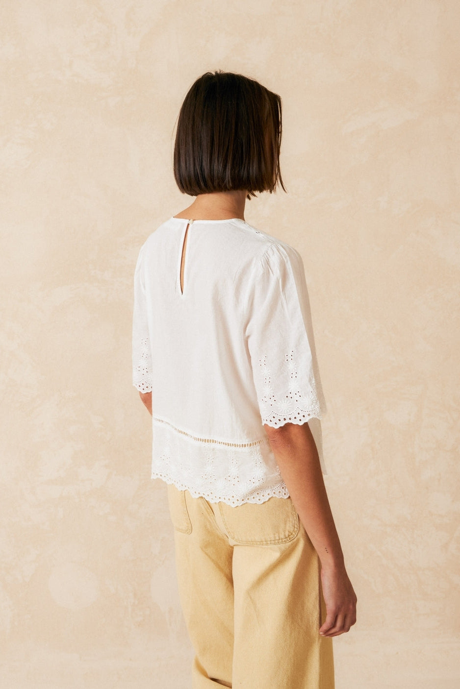 Short sleeve white v neck shirt with lace detailing. 