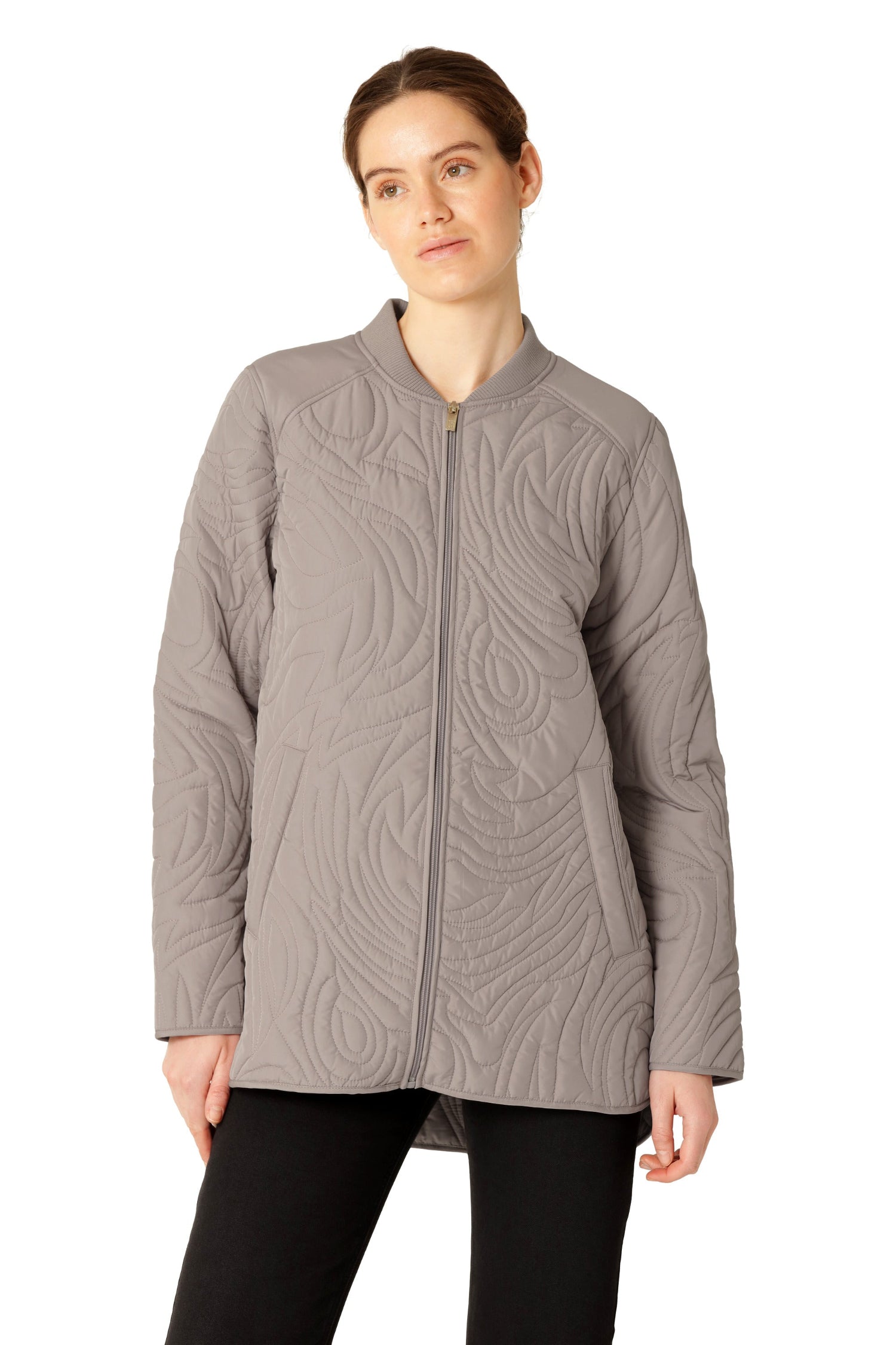 Woman wearing a gray quilted jacket on a white background