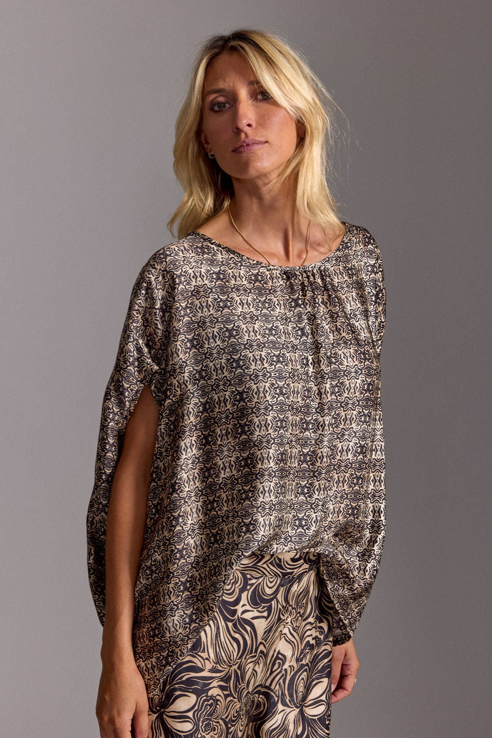 Woman wearing a patterned dress against a gray background