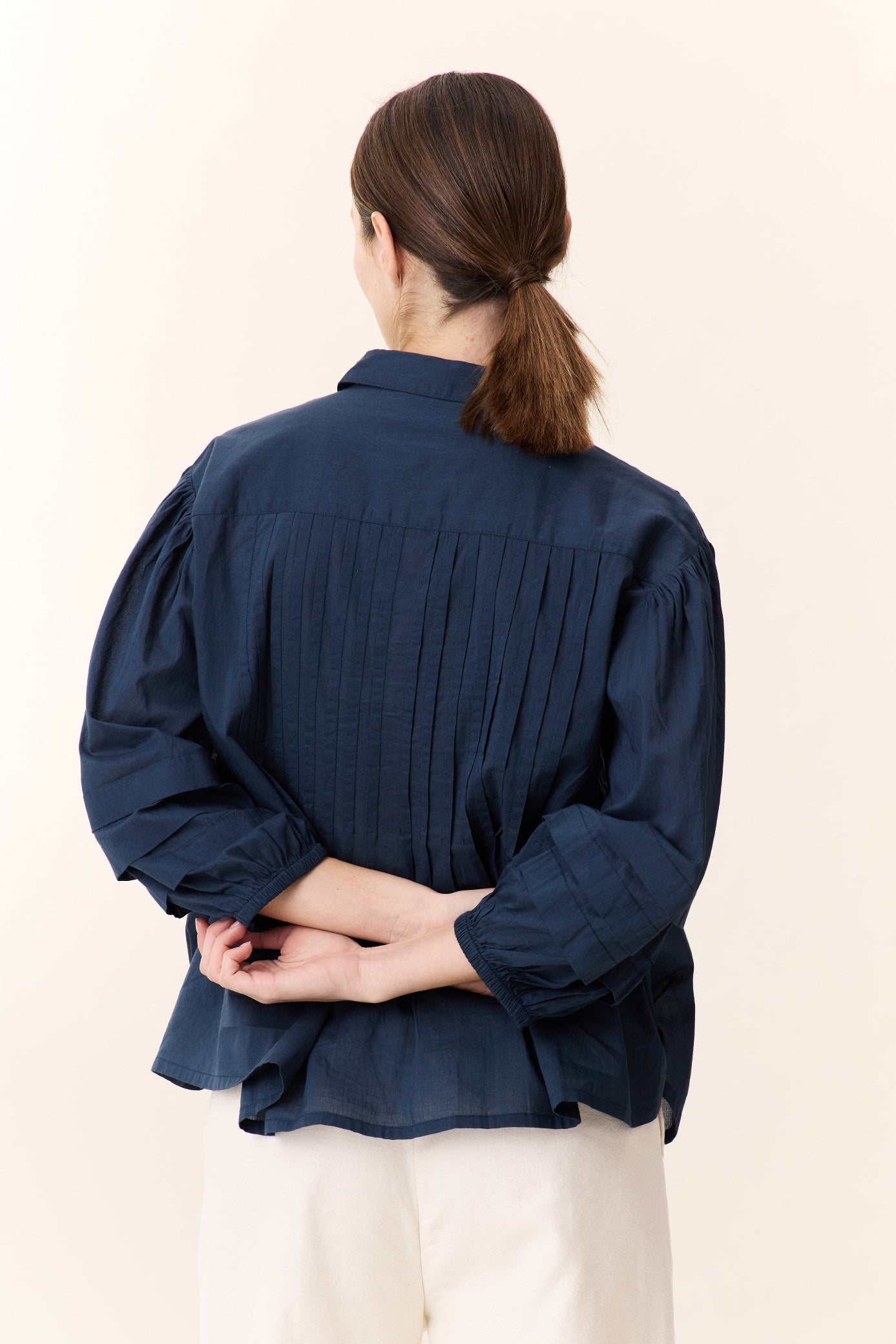 Model wearing a Navy blue  frill short sleeve shirt on a white background
