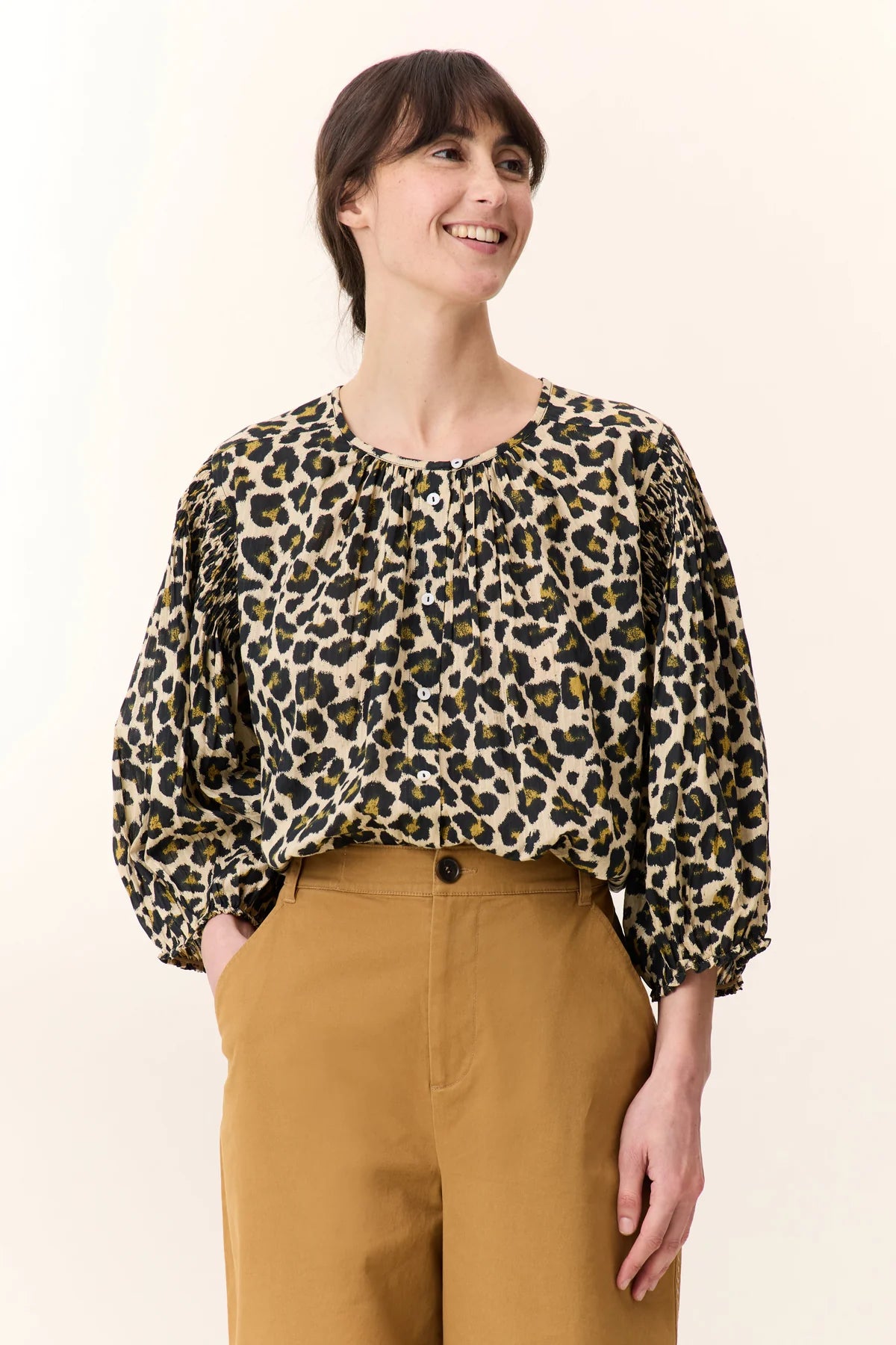 Model wearing leopard print blouse with a button detail  and balloon sleeves on a plain background
