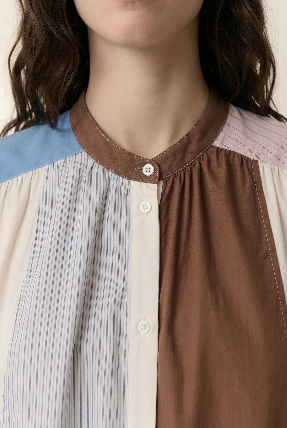 Close-up of a woman wearing a multicoloured dress with button up collar. 