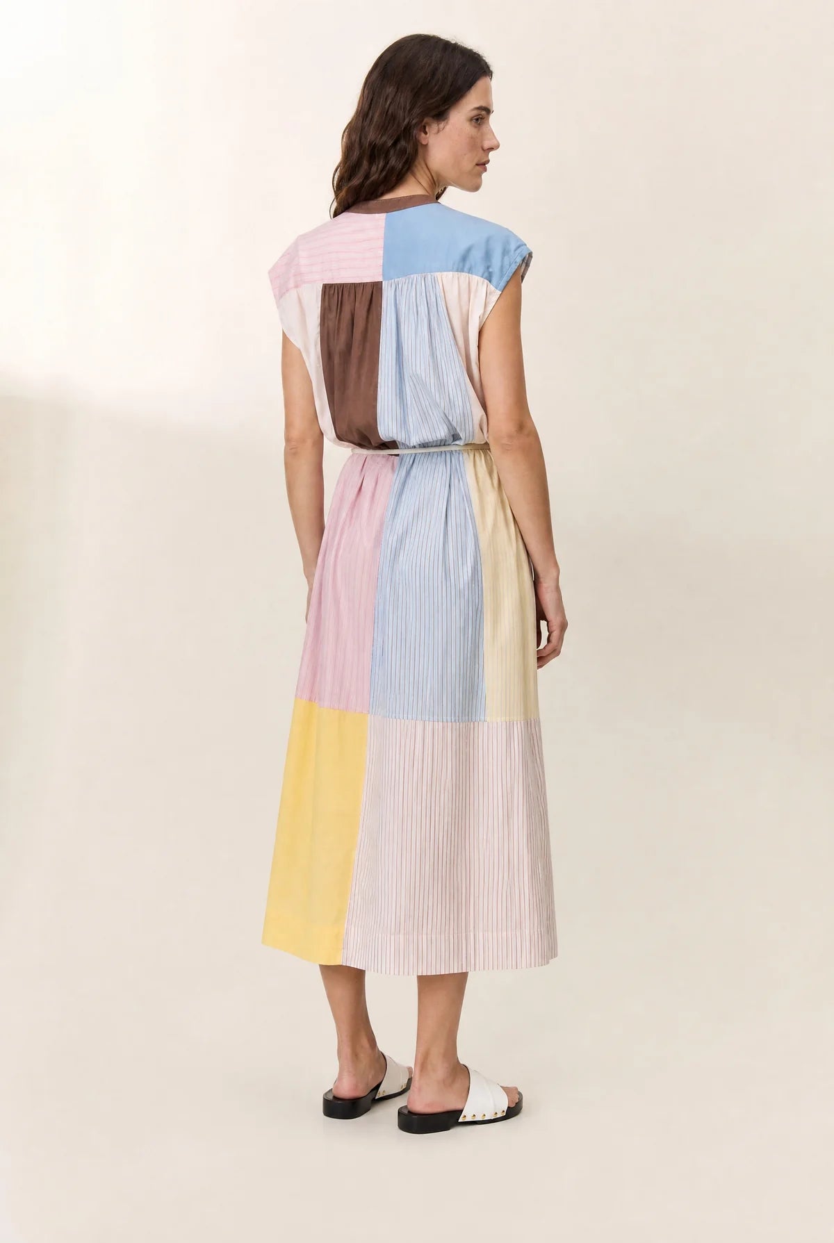 Woman wearing a multicolored dress on a plain background