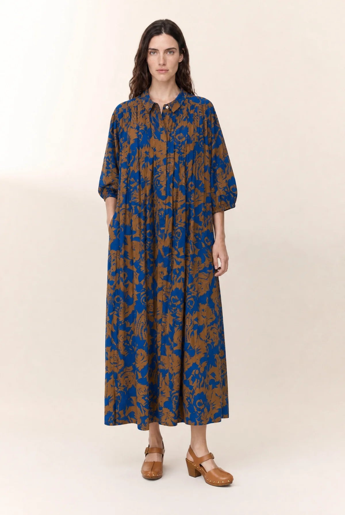 Women wearing a floral print midi dress shown on a plain background. 