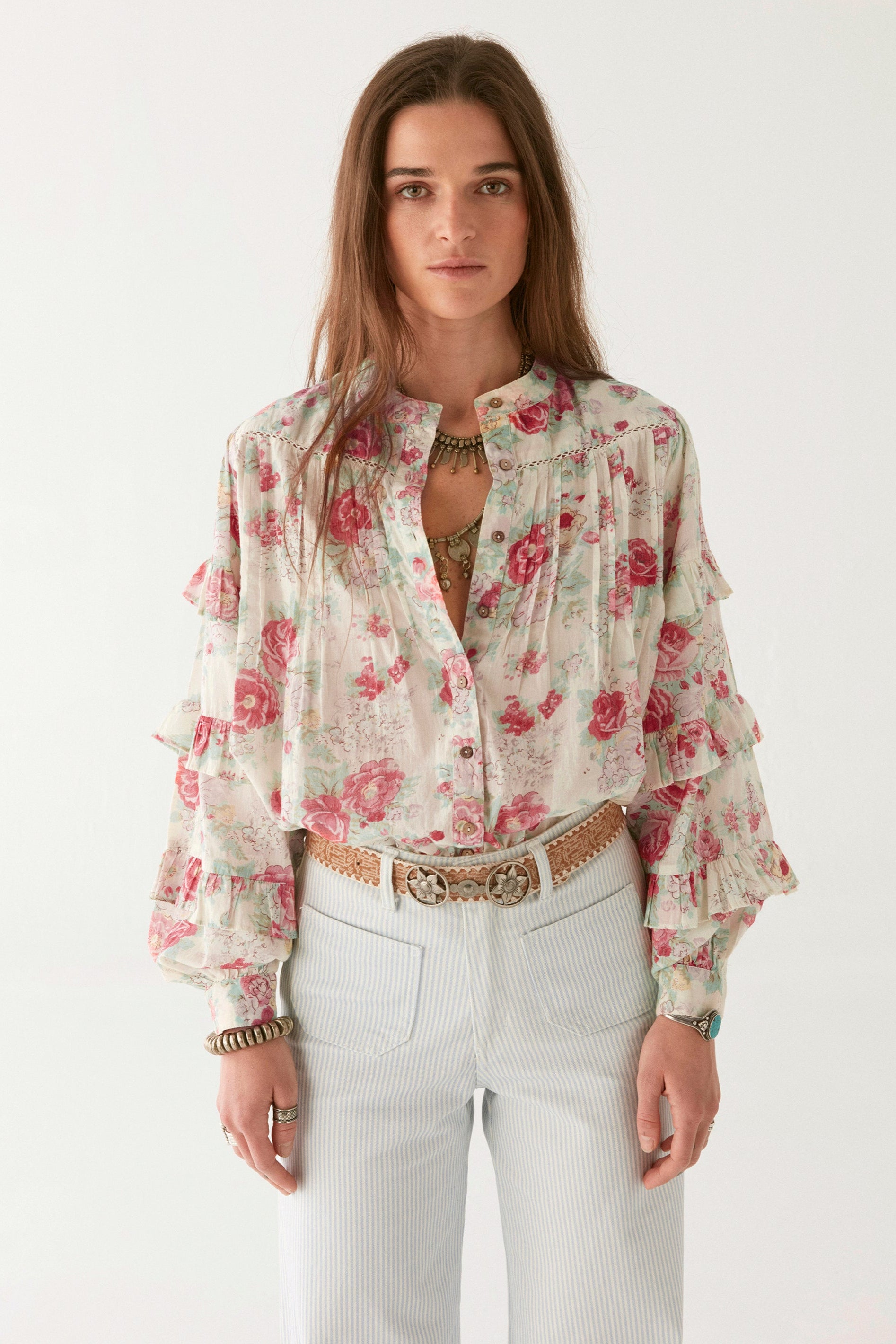 Pink floral blouse with ruffle sleeves on modal on a white background.   
