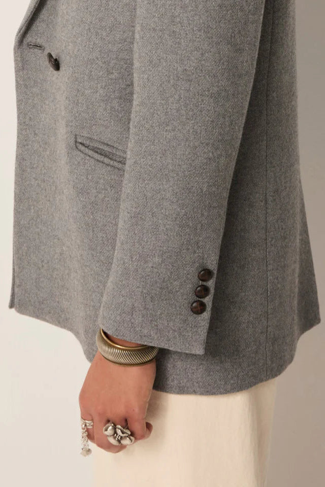 Gray blazer with buttons on a neutral background