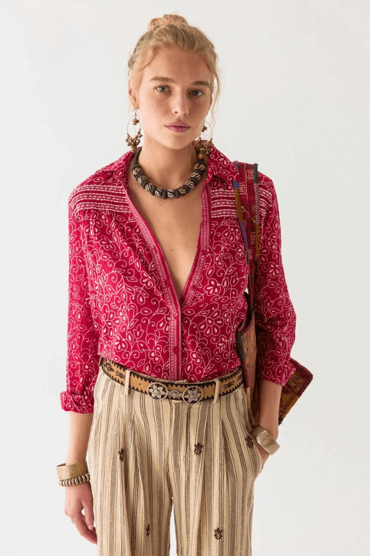 Woman wearing a red and white floral patterned shirt with a white background