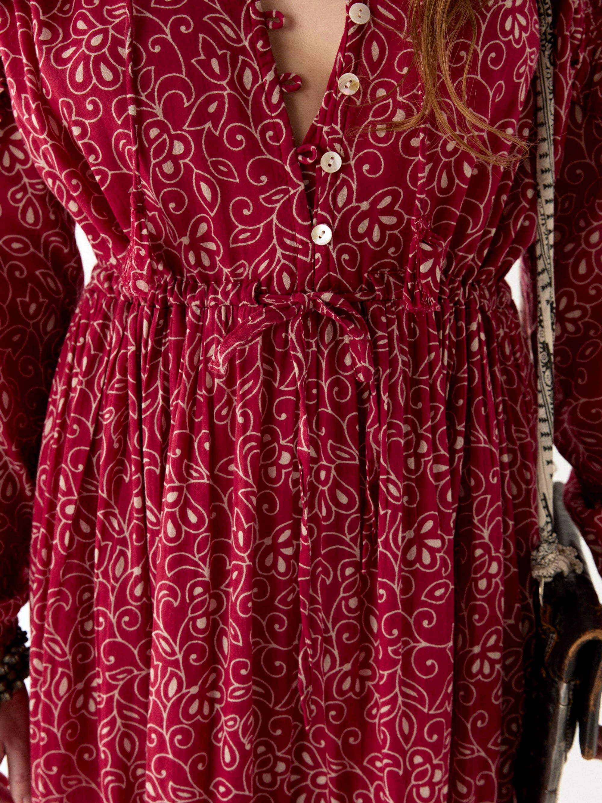 Chill red and ivory floral print floaty maxi dress worn by model close up button detail and front and waist tie.  
