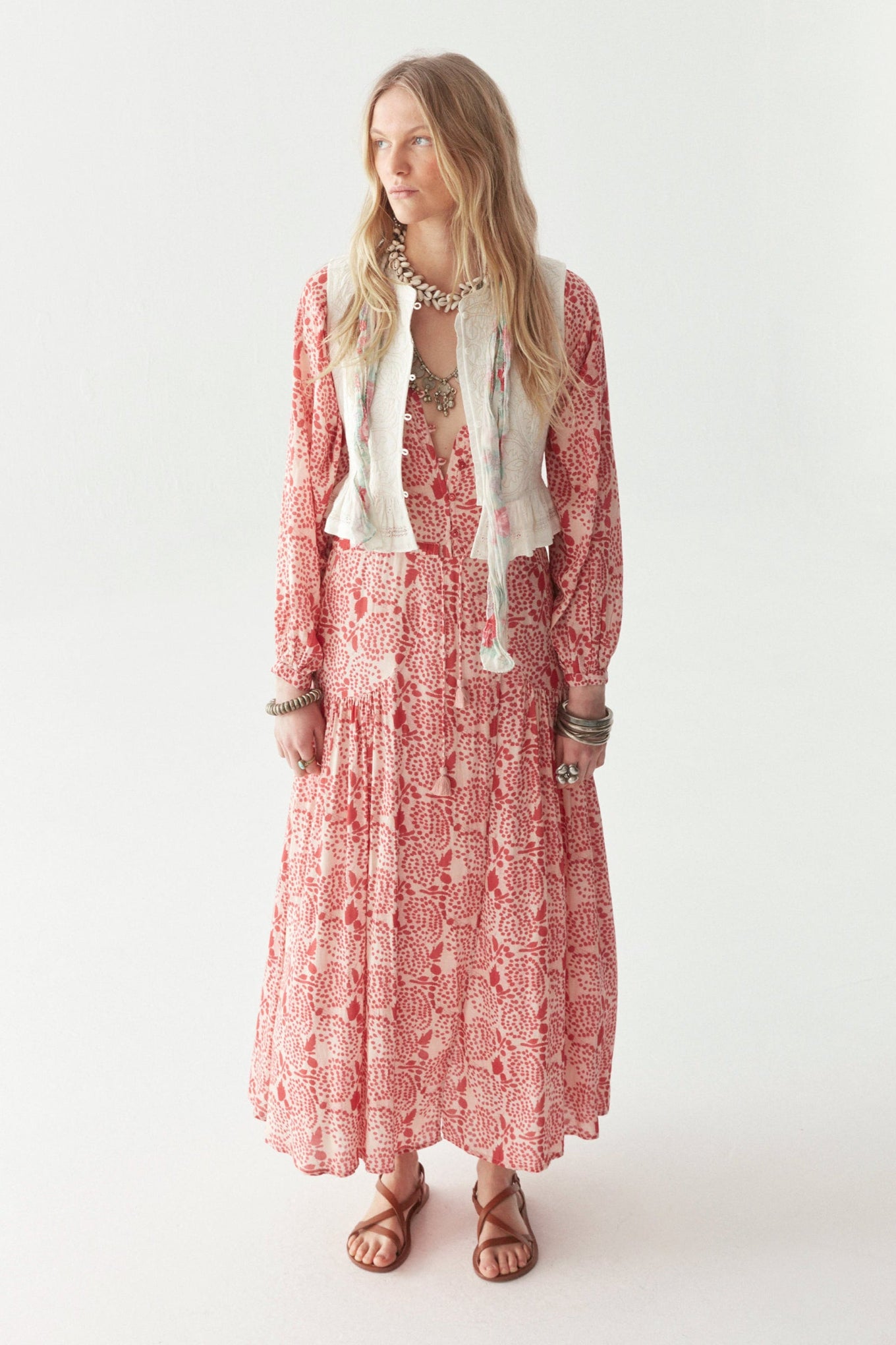 Pink and white patterned floral maxi dress by a person on a plain background. 