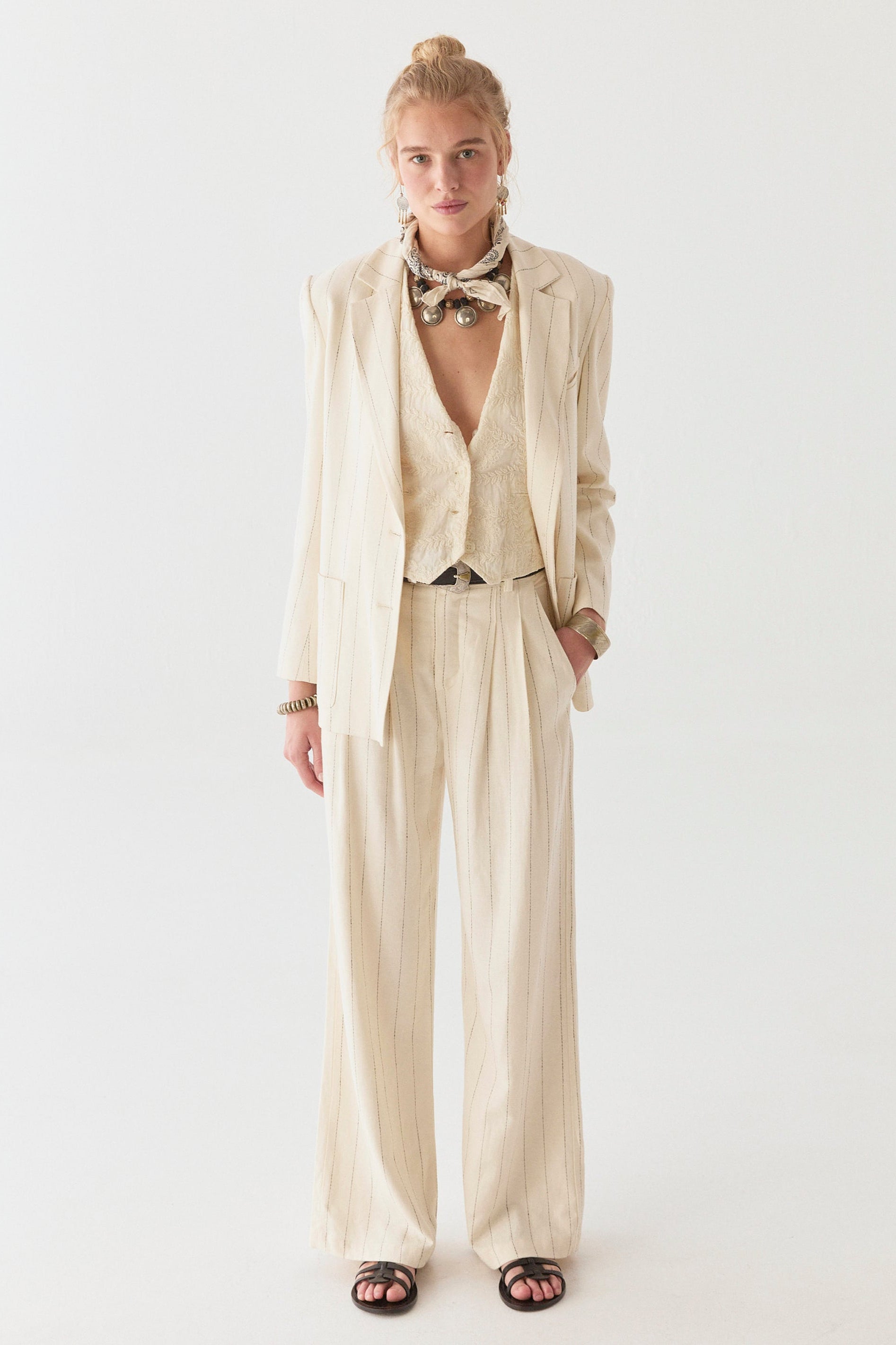 Model wearing linen cotton blend blazer in cream with navy stripe on a white background. 