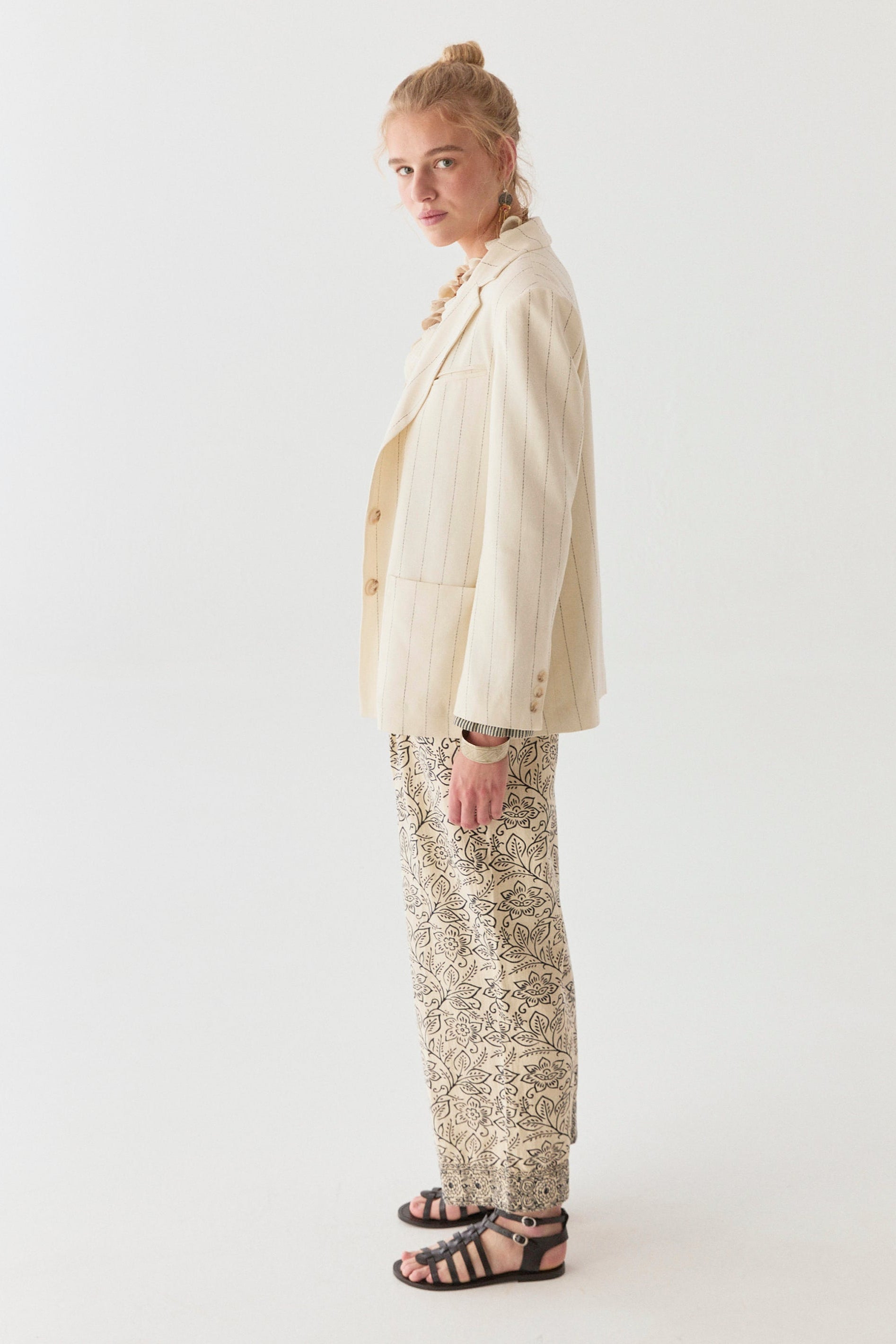 Model wearing linen cotton blend blazer in cream with navy stripe on a white background. 