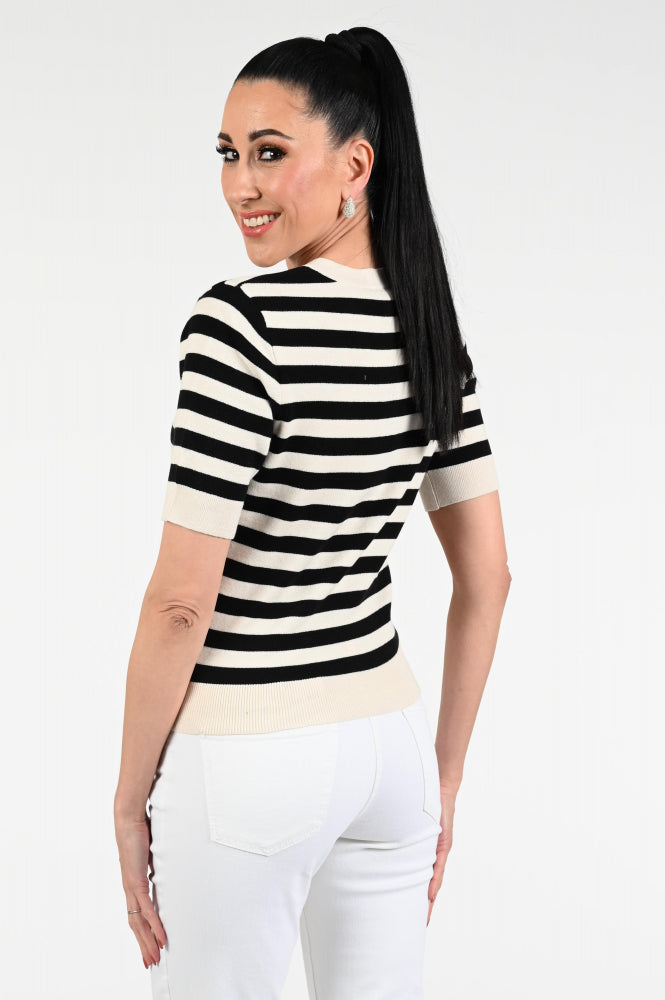 Woman wearing a black and white striped sweater with a plain background