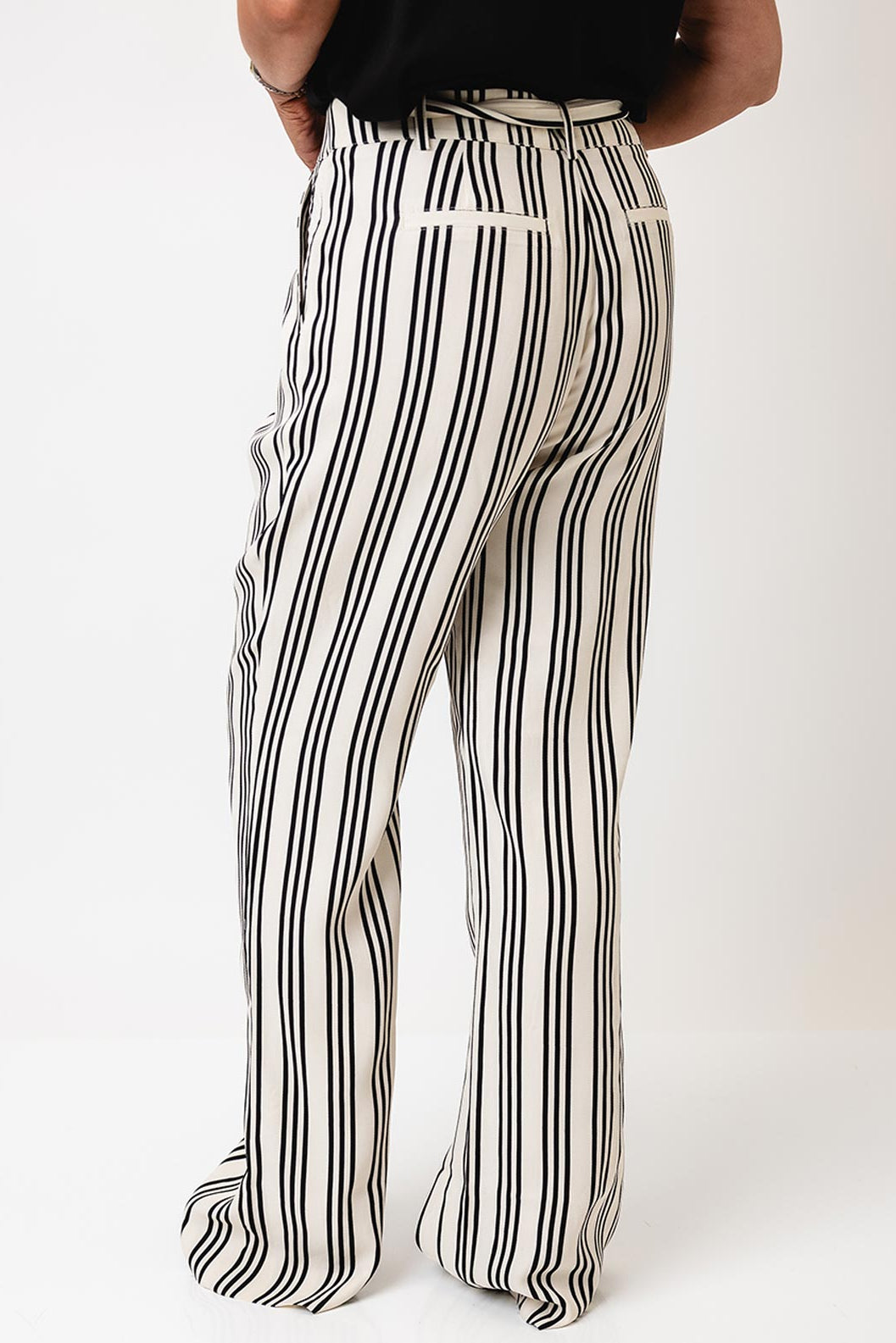 Black and white striped pants worn by a person on a white background
