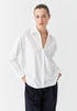 White cotton collared shirt with v neck and back yolk. 