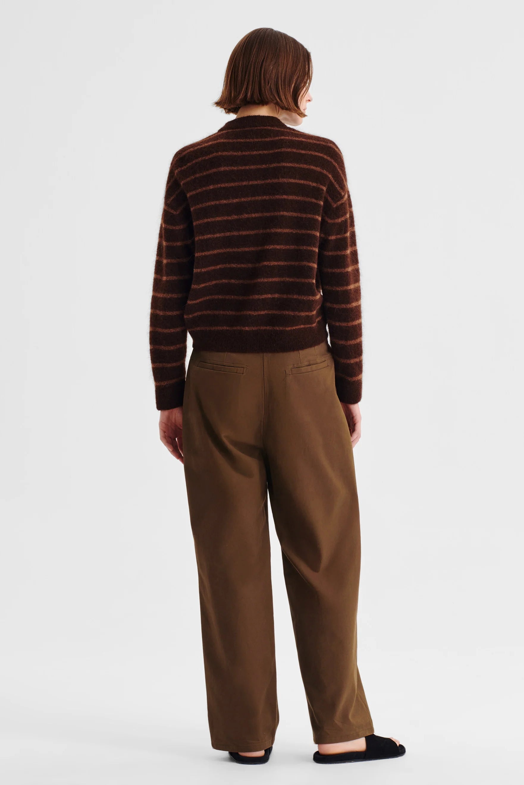 Women wearing stripe knit sweater and nutmeg clouded pant on a white background. 