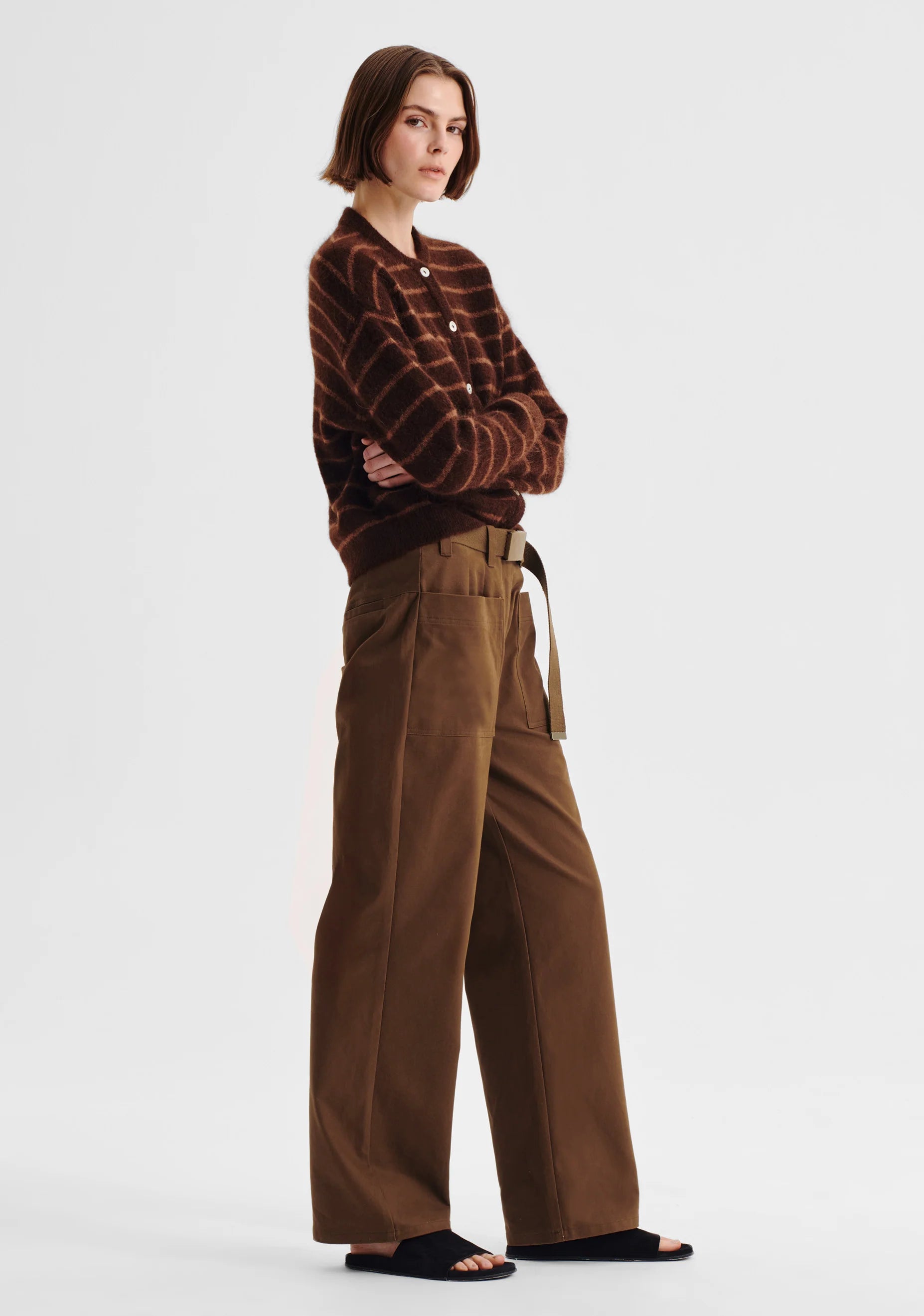 Women wearing stripe knit sweater and nutmeg clouded pant on a white background. 
