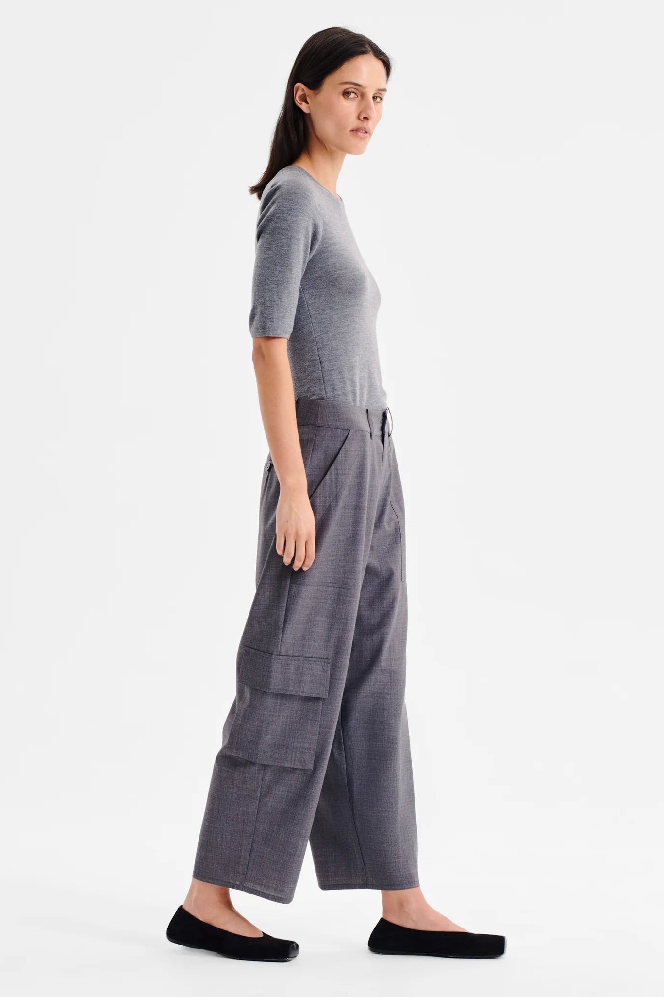 Women wearing charcoal grey cropped cargo pants and matching top on a white background. 