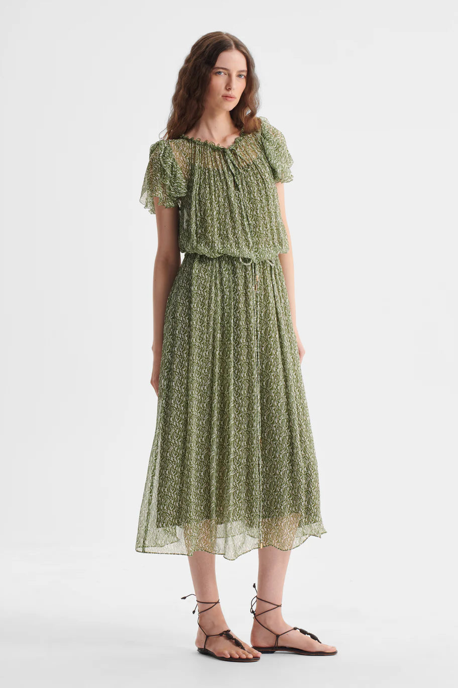 Woman wearing a green floral dress on a white background